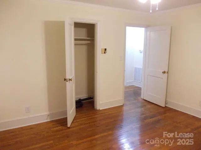 an empty room with wooden floor and entrance