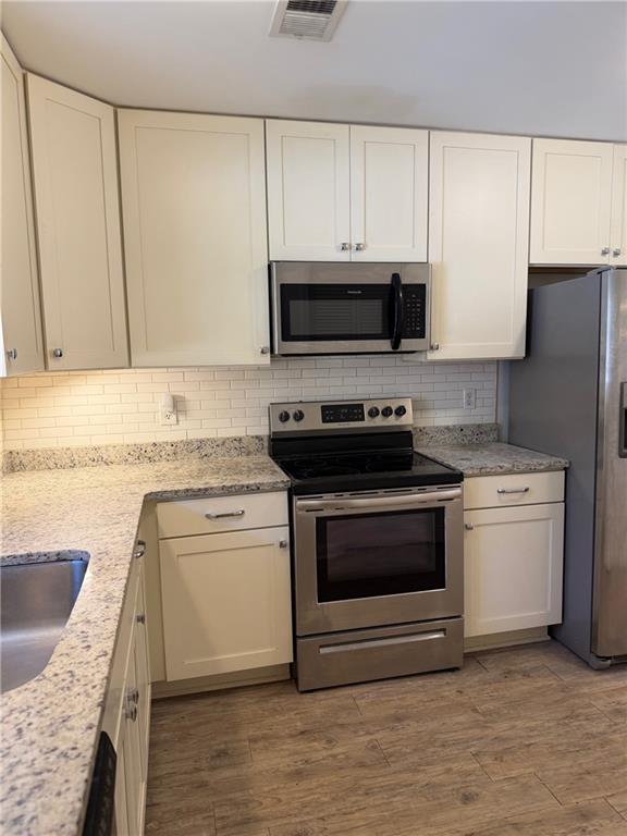 2912 Webb Bridge Road Alpharetta, GA 30009 - Photo 4 of 12 a kitchen with granite countertop a sink stove and refrigerator