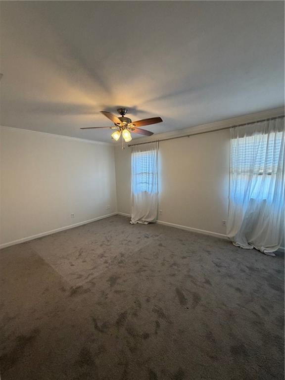 2912 Webb Bridge Road Alpharetta, GA 30009 - Photo 8 of 12 an empty room with windows and chandelier fan