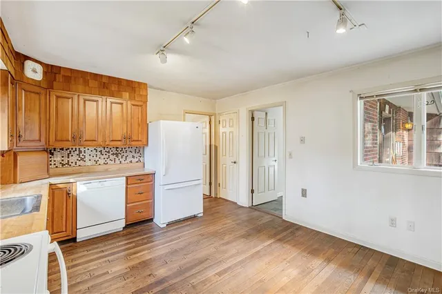 a view of kitchen with wooden floor and electronic appliances