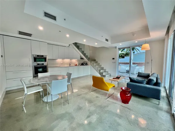 a living room with furniture and kitchen view