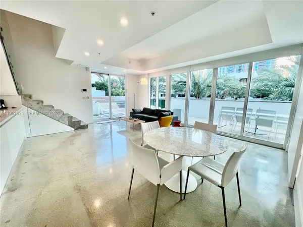 a dining room with furniture and a large window