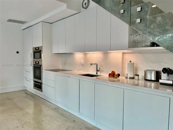 a kitchen with stainless steel appliances a sink a stove and cabinets