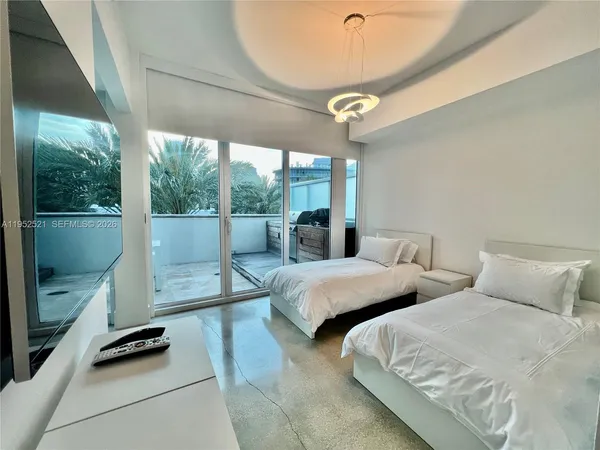 a bedroom with two beds and ceiling fan