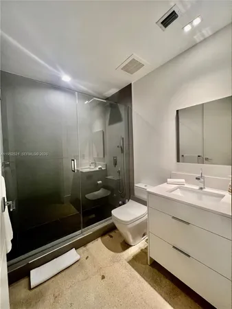 a bathroom with a sink a toilet a mirror and shower