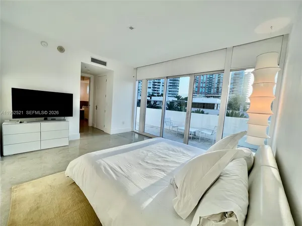 a bedroom with a large bed and a flat screen tv