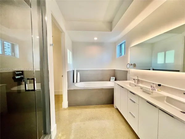 a bathroom with a tub sink and mirror