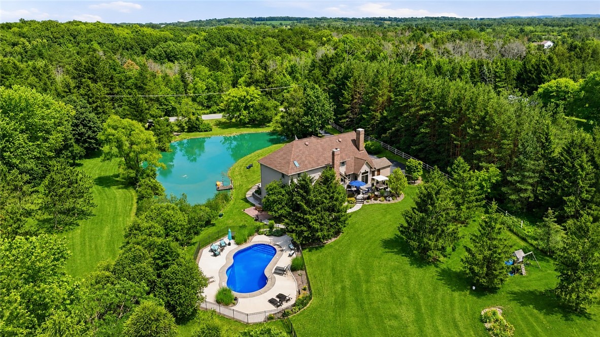 2057 Stirnie Road Victor, NY 14564 - Photo 46 of 48 A sweeping drone perspective capturing the entire 5.10 acre perimeter and the lush, rolling green countryside. This view illustrates the home's estate-like presence, offering vast open space and maximum quietude.
