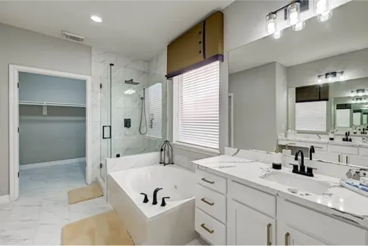 a bathroom with a tub sink and mirror