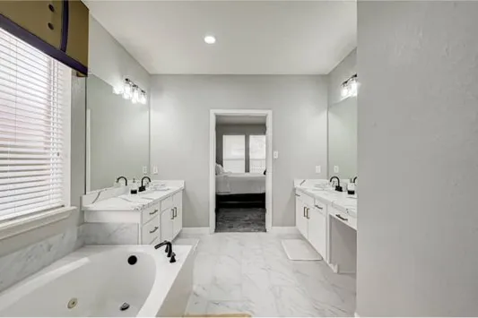 a bathroom with a bathtub sink and mirror