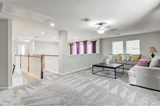 a living room with furniture and a ceiling fan