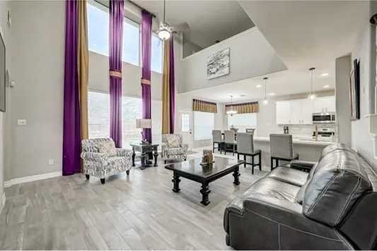 a living room with furniture and large windows