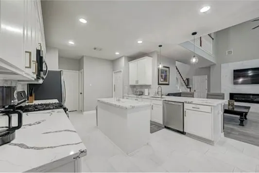 a kitchen with a sink stainless steel appliances and white cabinets