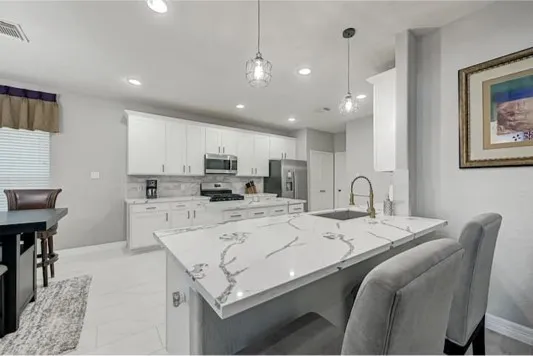 a large kitchen with kitchen island a sink table and chairs