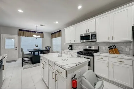 a kitchen with a sink stove and white cabinets