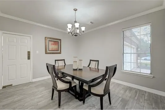 a view of a dining room with furniture a chandelier and wooden floor