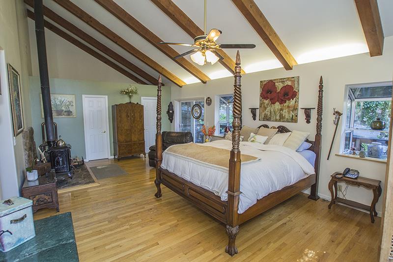 223 Ridge Road Woodside, CA 94062 - Photo 15 of 27 a large bedroom with a bed and wooden floor
