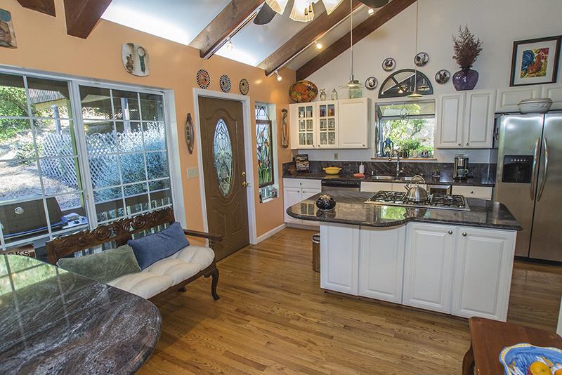 223 Ridge Road Woodside, CA 94062 - Photo 8 of 27 a kitchen with stainless steel appliances granite countertop a stove a refrigerator a sink and couches with wooden floor