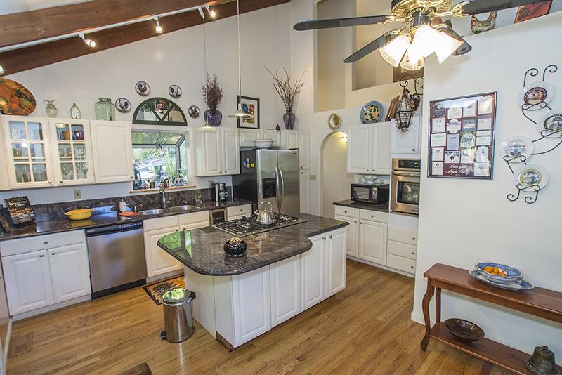 223 Ridge Road Woodside, CA 94062 - Photo 9 of 27 a kitchen with stainless steel appliances granite countertop a stove a sink dishwasher and cabinets with wooden floor