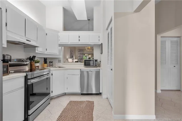 a kitchen with white cabinets and appliances