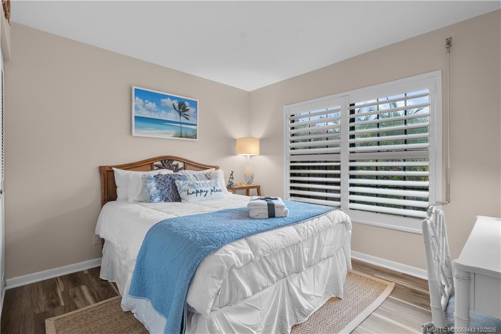 1544 Southwest Silver Pine Way, Unit 104F Palm City, FL 34990 - Photo 16 of 49 a bedroom with a bed and a painting on the wall