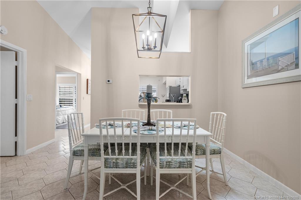 1544 Southwest Silver Pine Way, Unit 104F Palm City, FL 34990 - Photo 19 of 49 a view of a dining room with furniture and a chandelier
