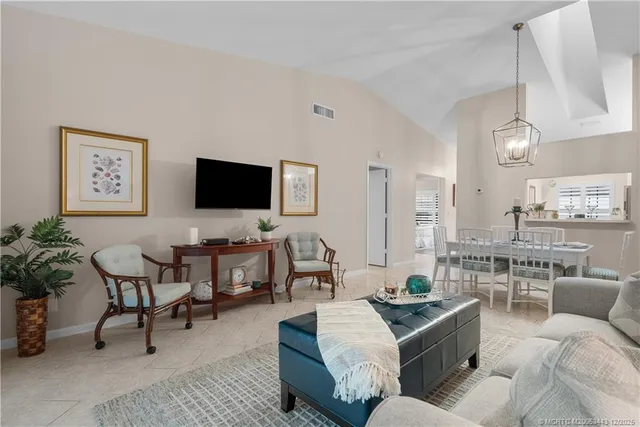 a living room with furniture kitchen view and a flat screen tv