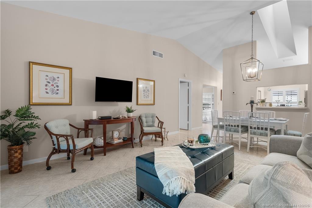 1544 Southwest Silver Pine Way, Unit 104F Palm City, FL 34990 - Photo 21 of 49 a living room with furniture kitchen view and a flat screen tv