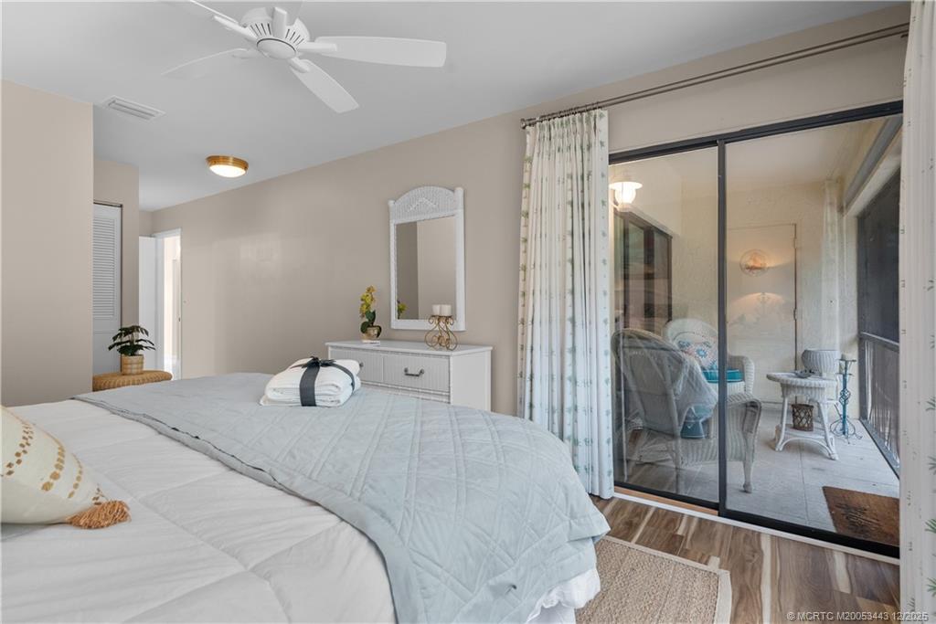 1544 Southwest Silver Pine Way, Unit 104F Palm City, FL 34990 - Photo 26 of 49 a bedroom with a large bed and a chandelier