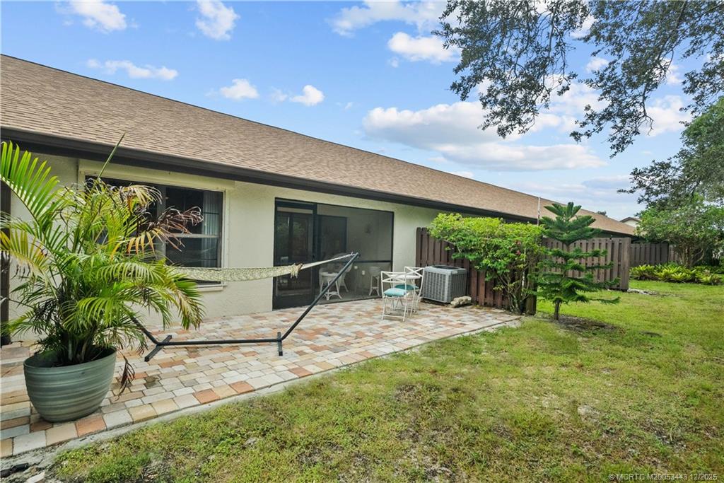 1544 Southwest Silver Pine Way, Unit 104F Palm City, FL 34990 - Photo 29 of 49 a view of a patio with table and chairs potted plants and a large tree