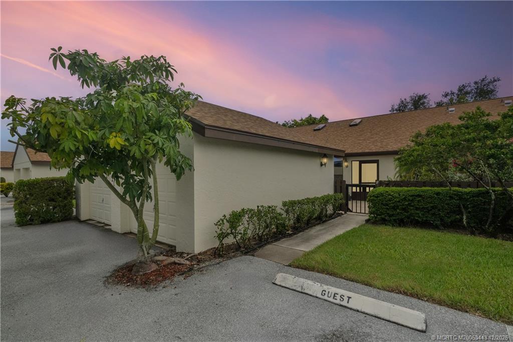 1544 Southwest Silver Pine Way, Unit 104F Palm City, FL 34990 - Photo 34 of 49 a view of a backyard with potted plants and a large tree