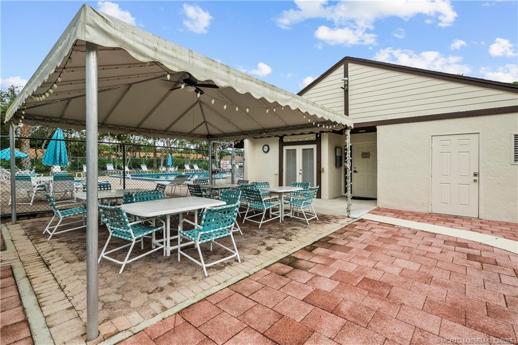 1544 Southwest Silver Pine Way, Unit 104F Palm City, FL 34990 - Photo 48 of 49 a patio with a table and chairs