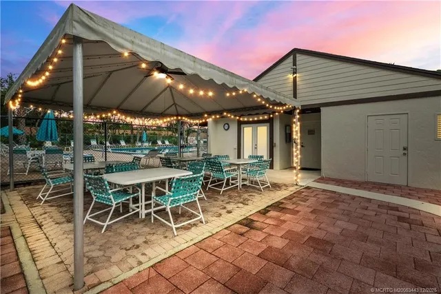 a view of a patio with a table and chairs under an umbrella