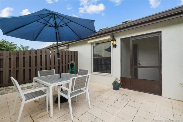 a view of a patio with a table and chairs under an umbrella