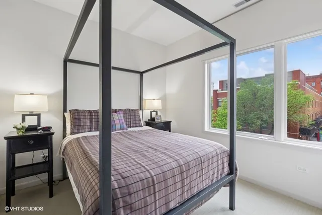 a bedroom with a bed and a large window