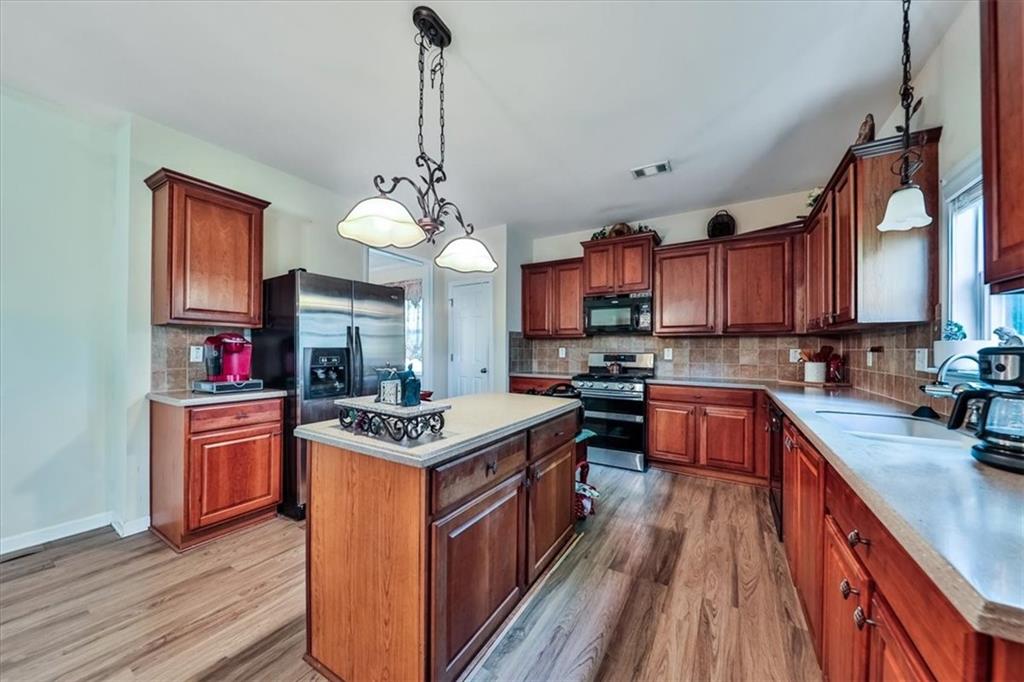 176 Oakland Way Dallas, GA 30157 - Photo 23 of 74 a kitchen with stainless steel appliances granite countertop a stove and a sink