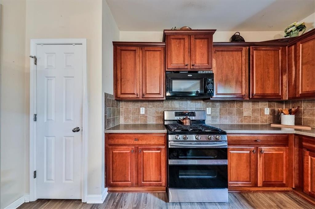 176 Oakland Way Dallas, GA 30157 - Photo 25 of 74 a kitchen with granite countertop a stove top oven microwave and cabinets