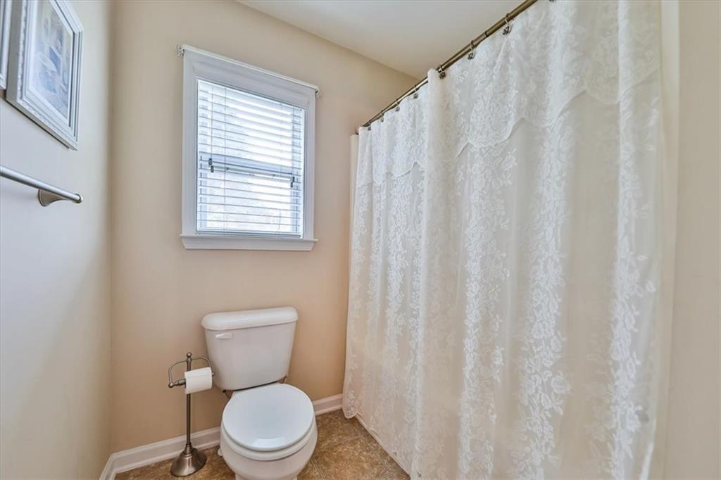 176 Oakland Way Dallas, GA 30157 - Photo 34 of 74 a white toilet sitting next to a white curtain