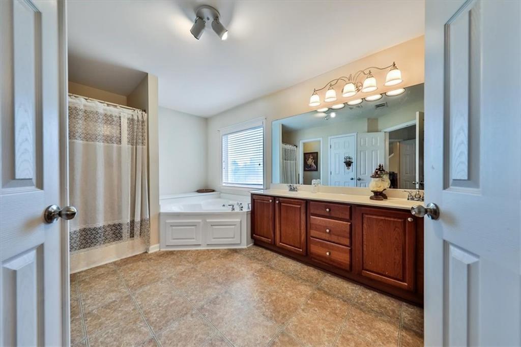 176 Oakland Way Dallas, GA 30157 - Photo 42 of 74 a spacious bathroom with a granite countertop sink a toilet and a mirror