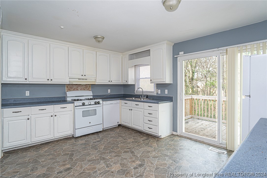 214 Lansdowne Road Fayetteville, NC 28314 - Photo 6 of 22 a kitchen with granite countertop a stove a sink and white cabinets