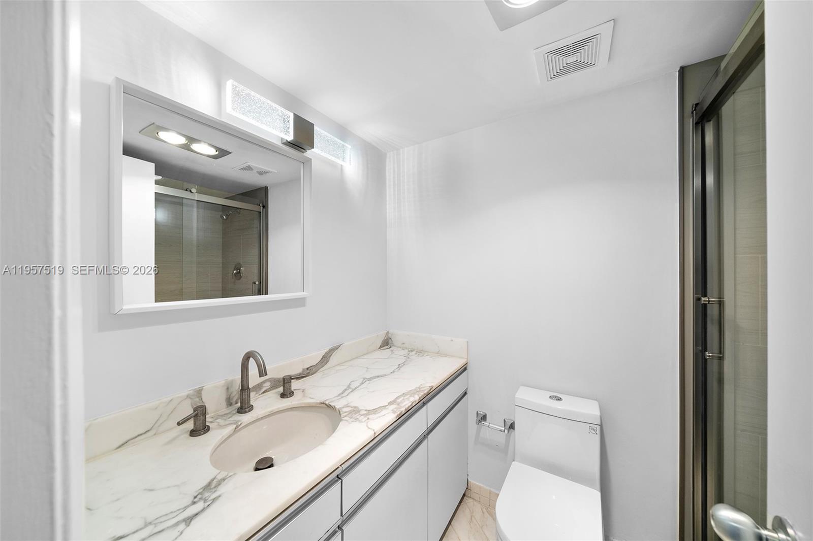 9 Island Avenue, Unit 710 Miami Beach, FL 33139 - Photo 12 of 15 a bathroom with a toilet a sink a mirror and vanity