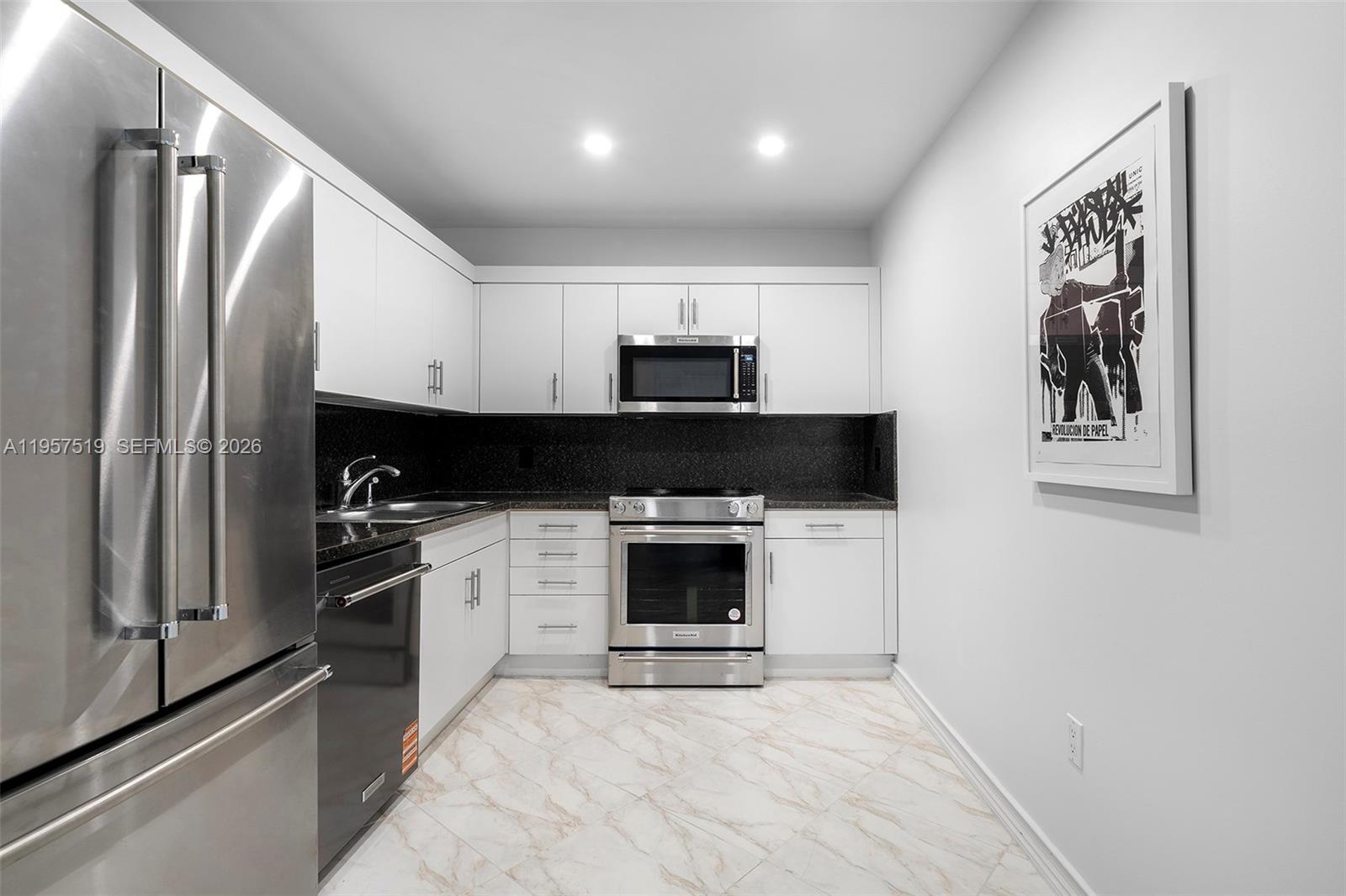 9 Island Avenue, Unit 710 Miami Beach, FL 33139 - Photo 6 of 15 a kitchen with granite countertop a stove and a refrigerator