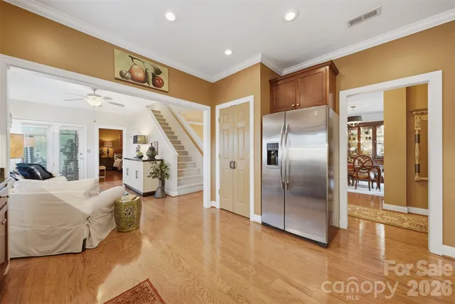 a living room with furniture with kitchen view and a chandelier