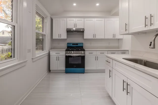 a kitchen with a stove top oven sink and cabinets