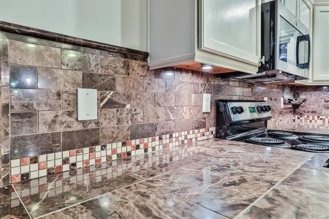 a kitchen with stainless steel appliances granite countertop a sink stove and microwave