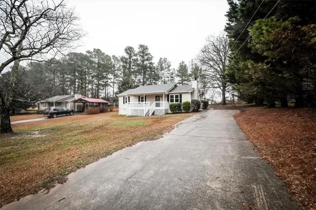 a view of house with car parked beside of road