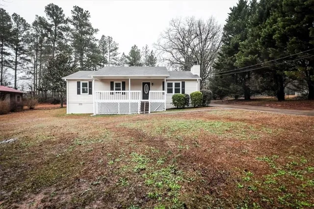 a front view of a house with a yard and trees