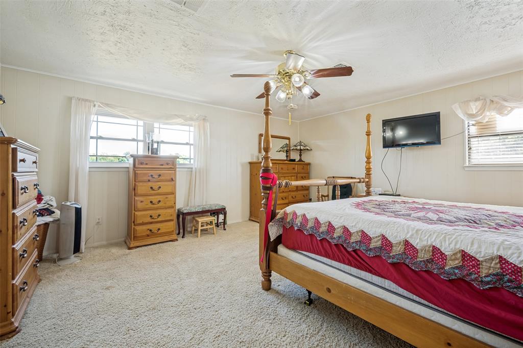 117 County Road Decatur, TX 76234 - Photo 23 of 40 Carpeted flooring, paneled walls, windows with blinds and sheer curtains, and a ceiling fan with integrated lighting