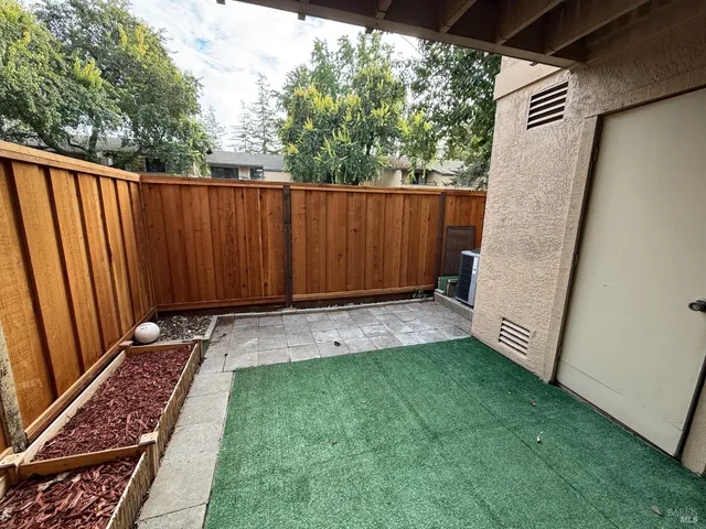 a view of a backyard with wooden fence