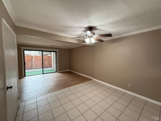 a view of an empty room with a chandelier fan
